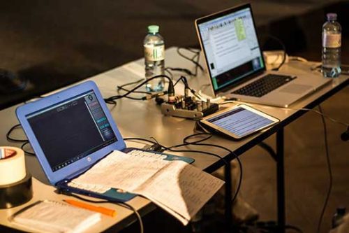 water bottles, laptops, wires on table top. Entrepreneurship, online business, scale, business growth