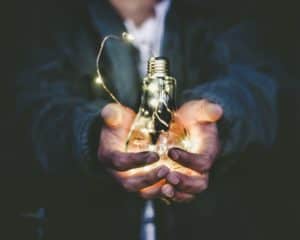 Business man holding light bulb.