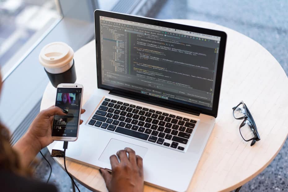 man holding coffee on laptop computer