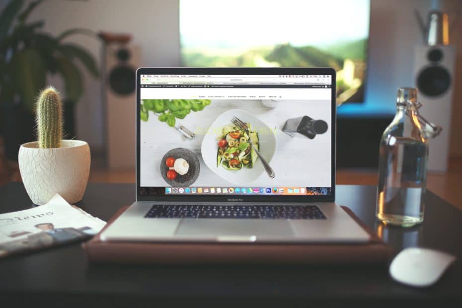 Website on computer screen on top of table.