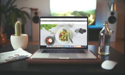 Website on computer screen on top of table.